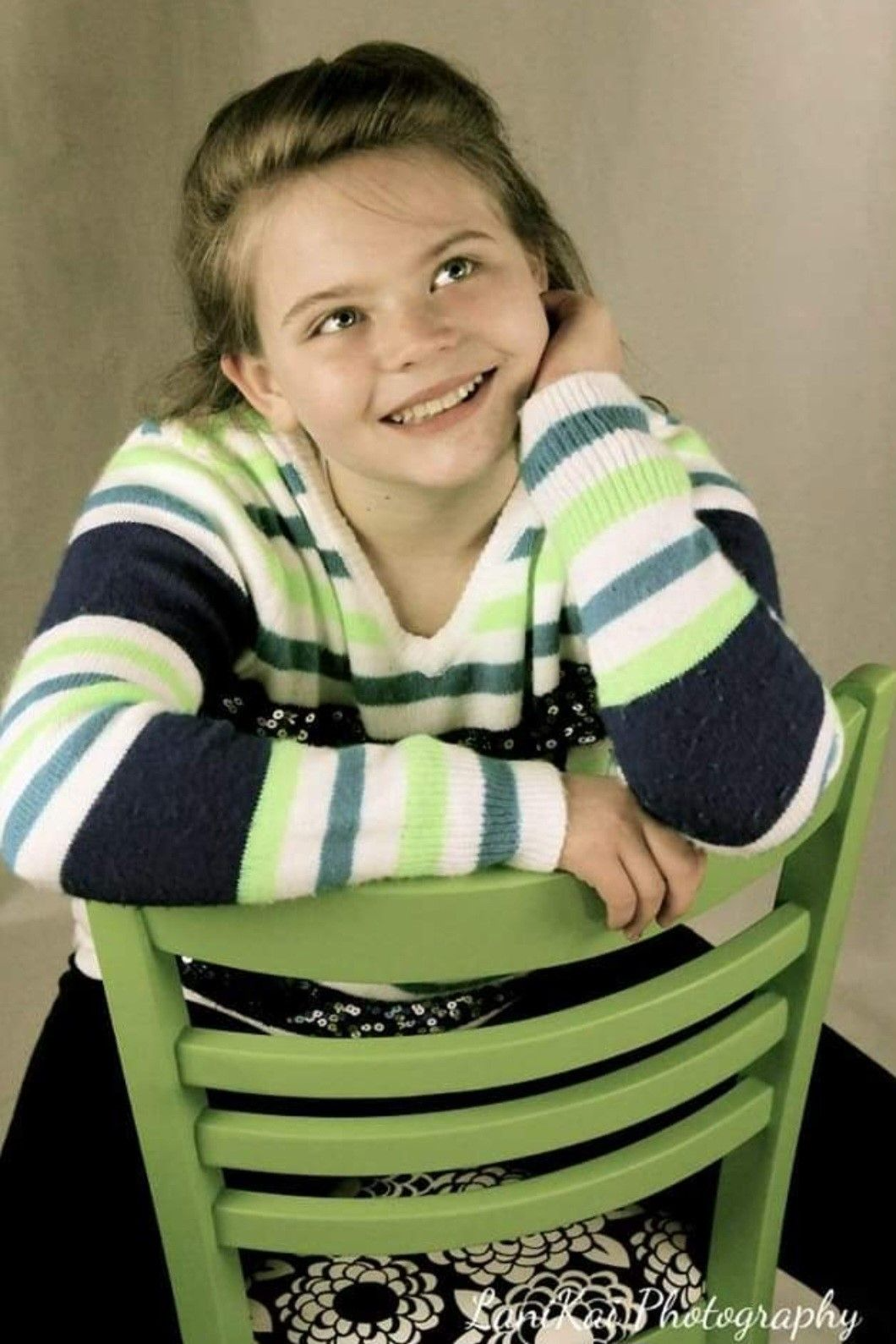Cute Picture of a Kid Sitting on a Green Chair