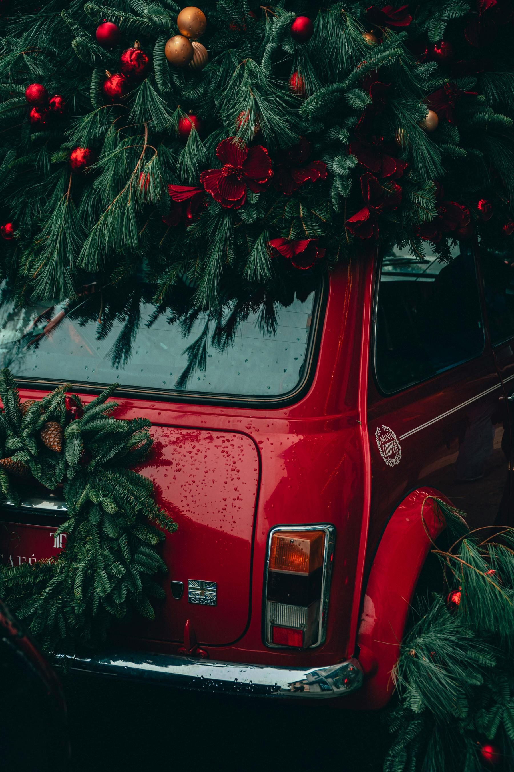 A red car with a christmas tree on top of it.