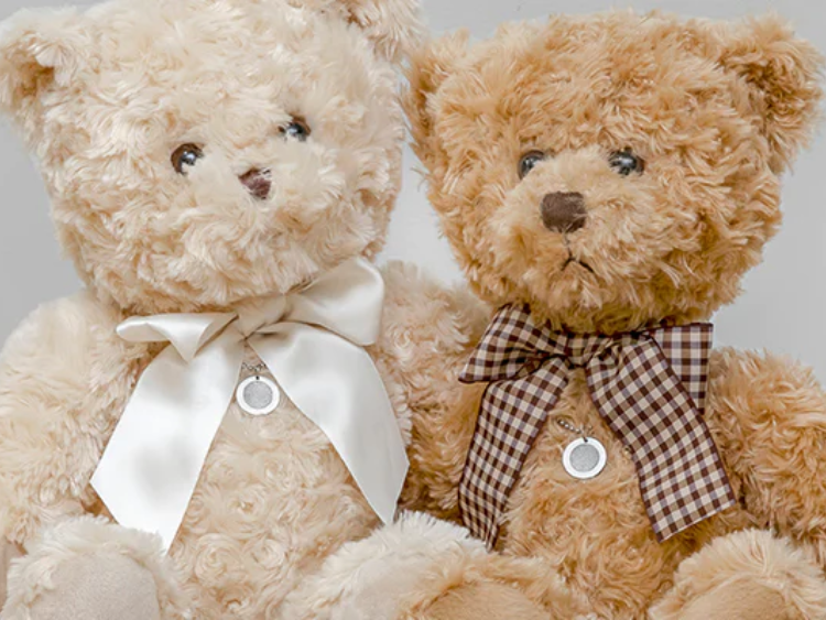 Two teddy bears are sitting next to each other wearing bow ties.