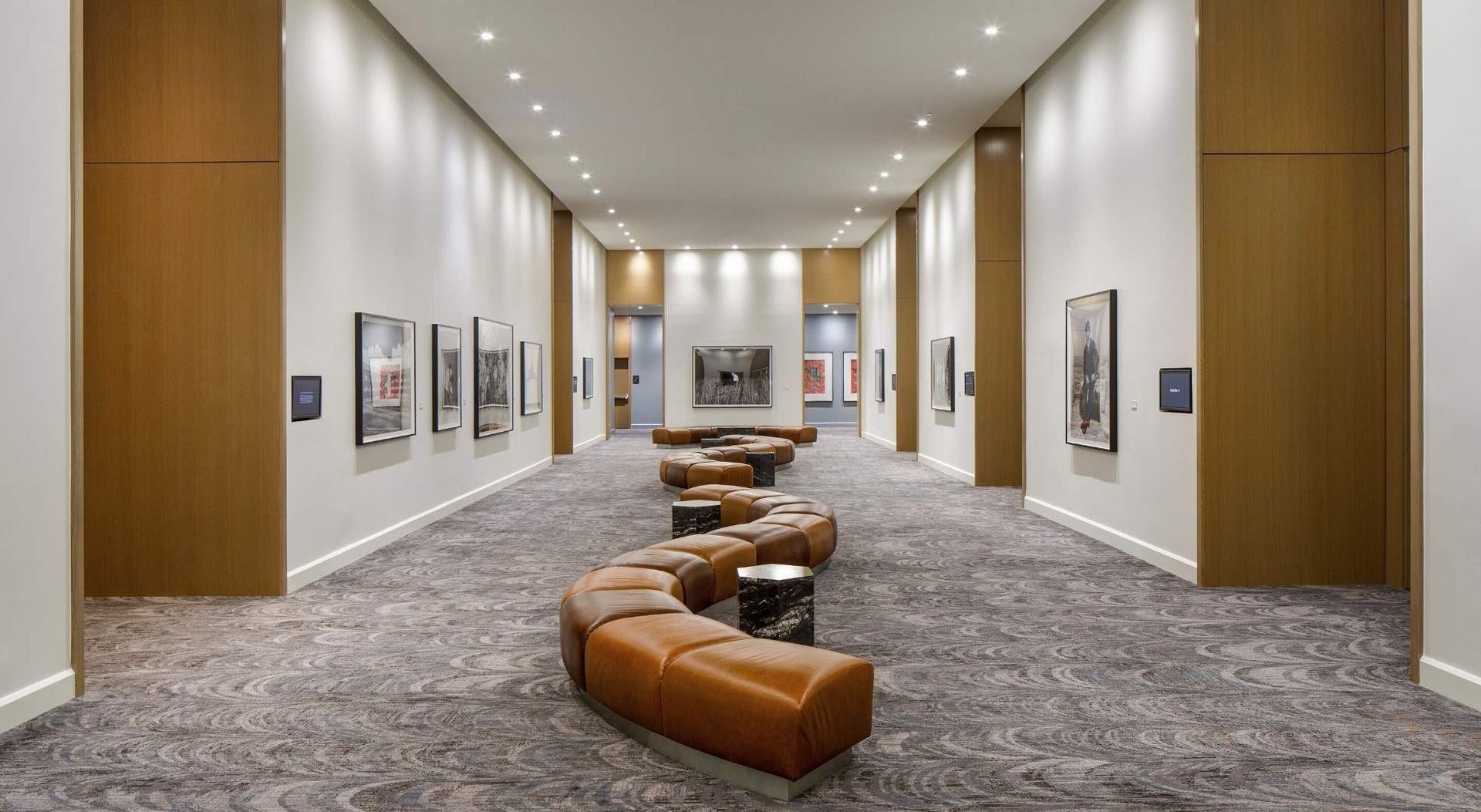 A long hallway with a row of benches in the middle.