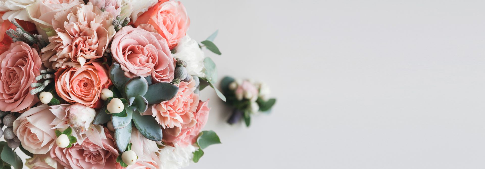 A bouquet of pink roses and carnations on a white background.