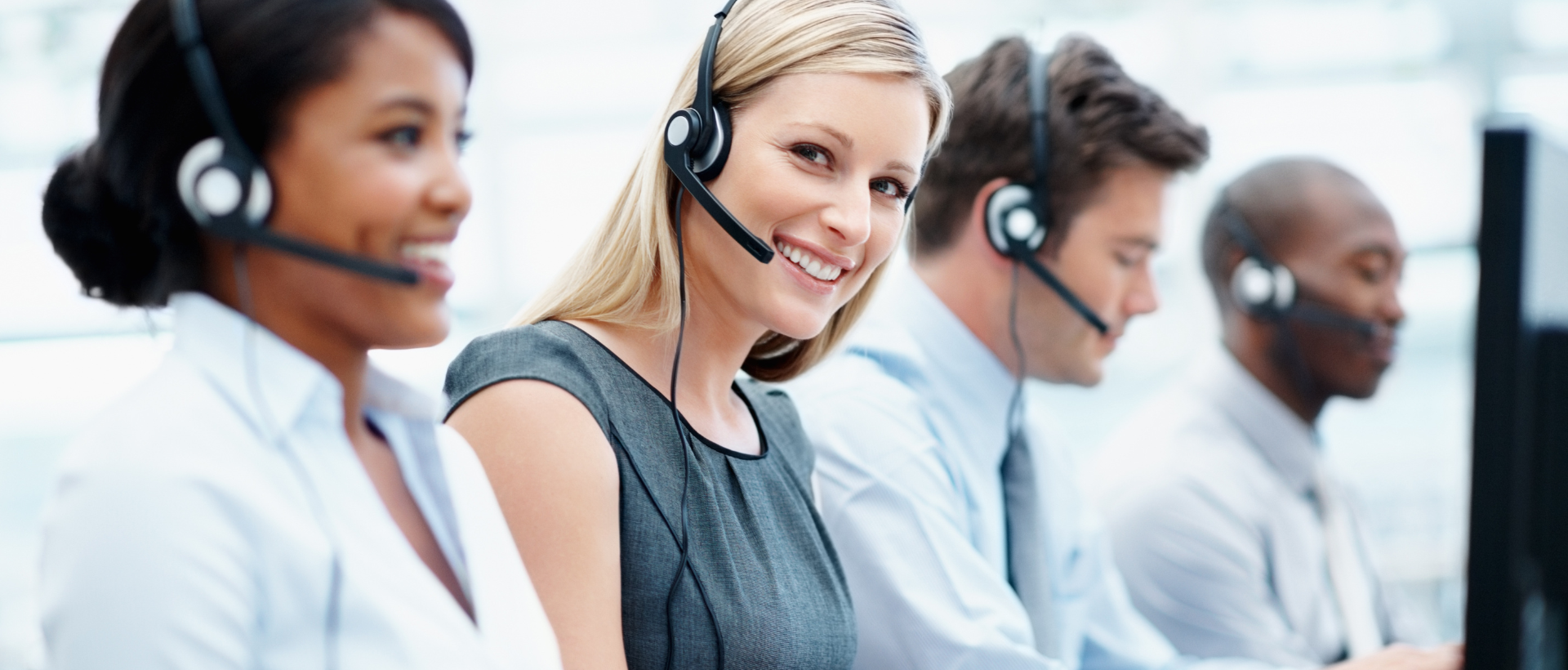 A group of people wearing headsets in a call center