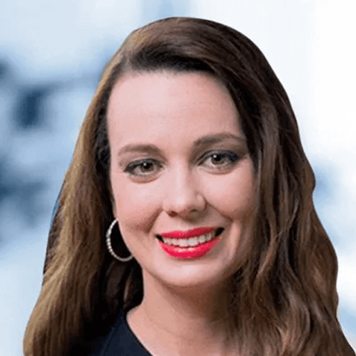 A woman wearing red lipstick and hoop earrings is smiling for the camera.