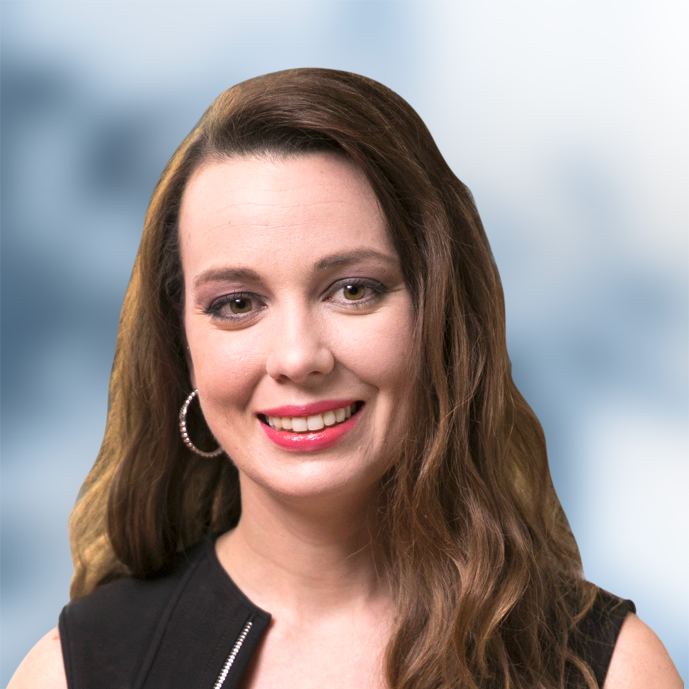 A woman wearing hoop earrings and a black top smiles for the camera