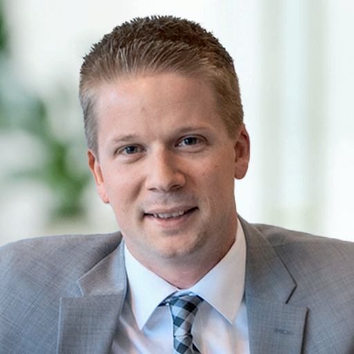 A man in a suit and tie is smiling for the camera