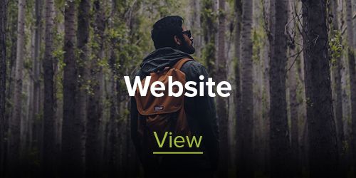 A man with a backpack is standing in the middle of a forest.