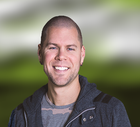 A man wearing a hoodie and a camo shirt is smiling for the camera.