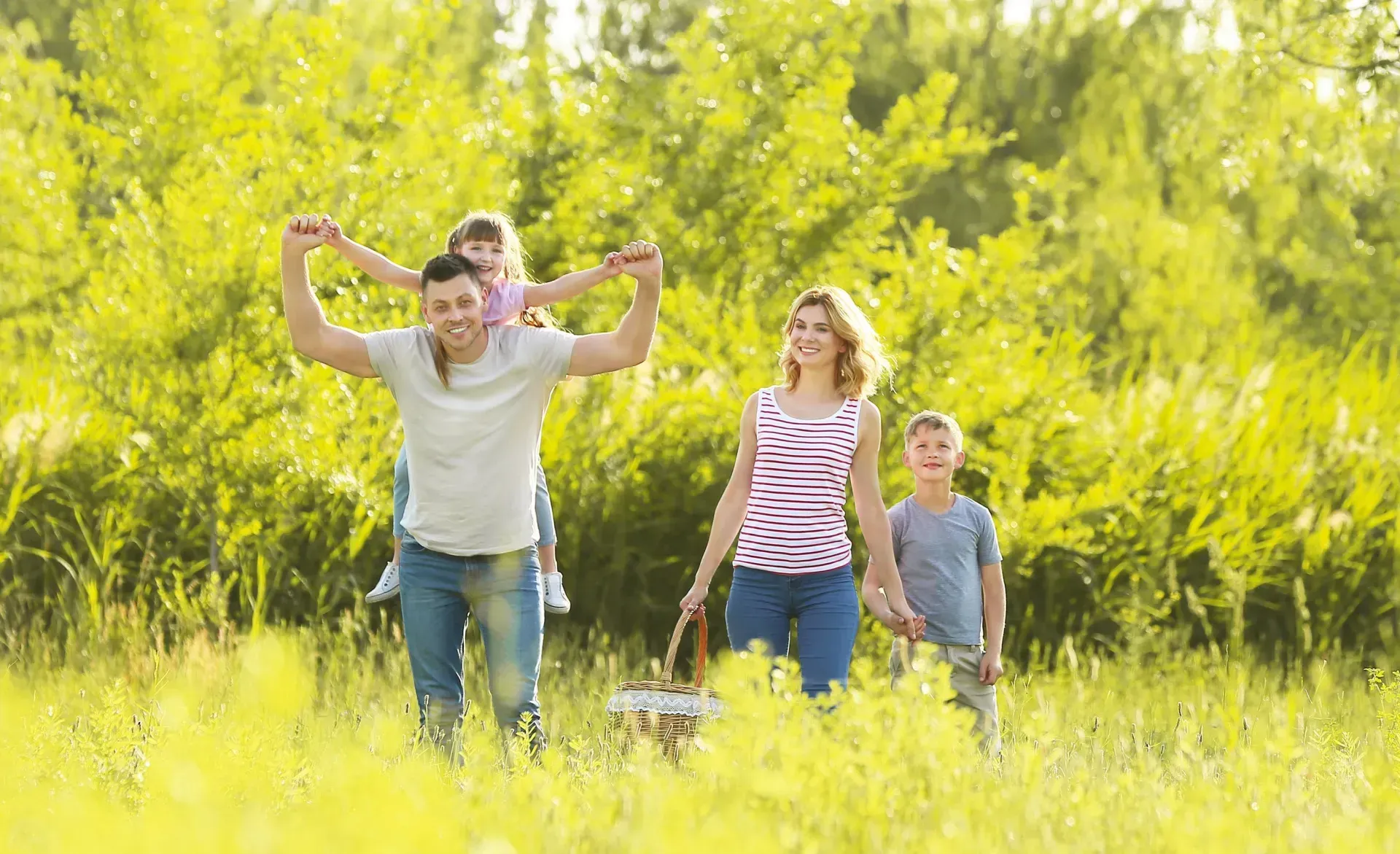 A boy is running towards an elderly couple sitting on a blanket in the grass.