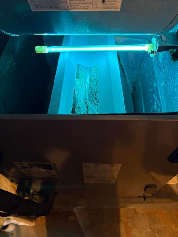 Blue-lit aquarium filter with a glowing tube above a tank interior and equipment below