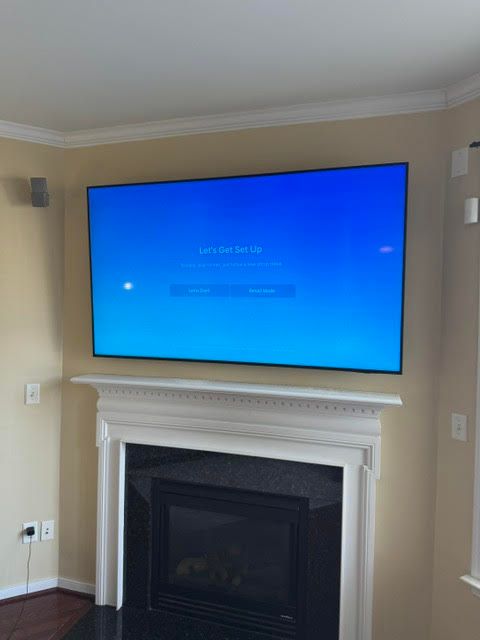 Wall-mounted TV above a white fireplace in a beige living room
