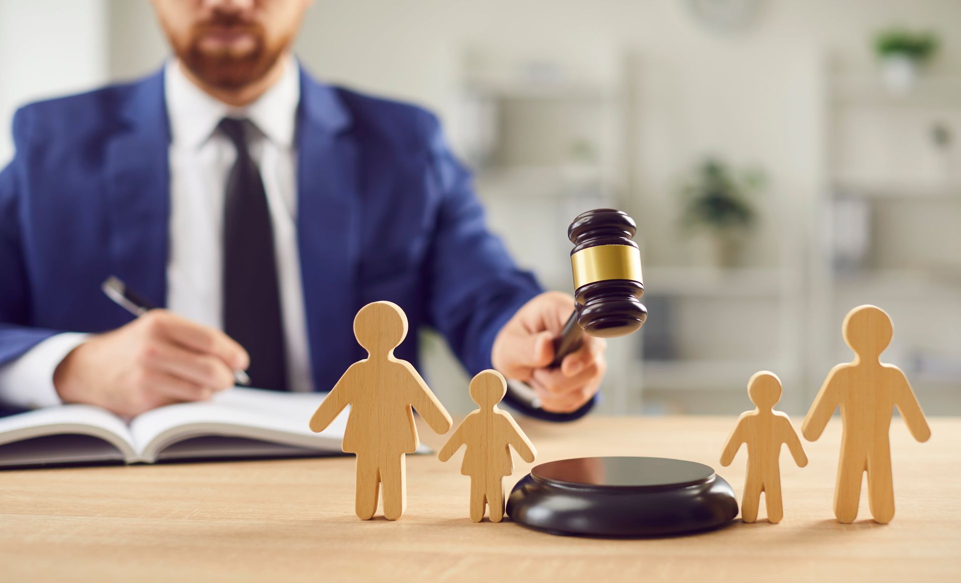 A judge is holding a gavel in front of a wooden family.