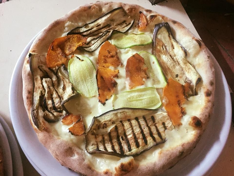 Una pizza con verdure sopra
