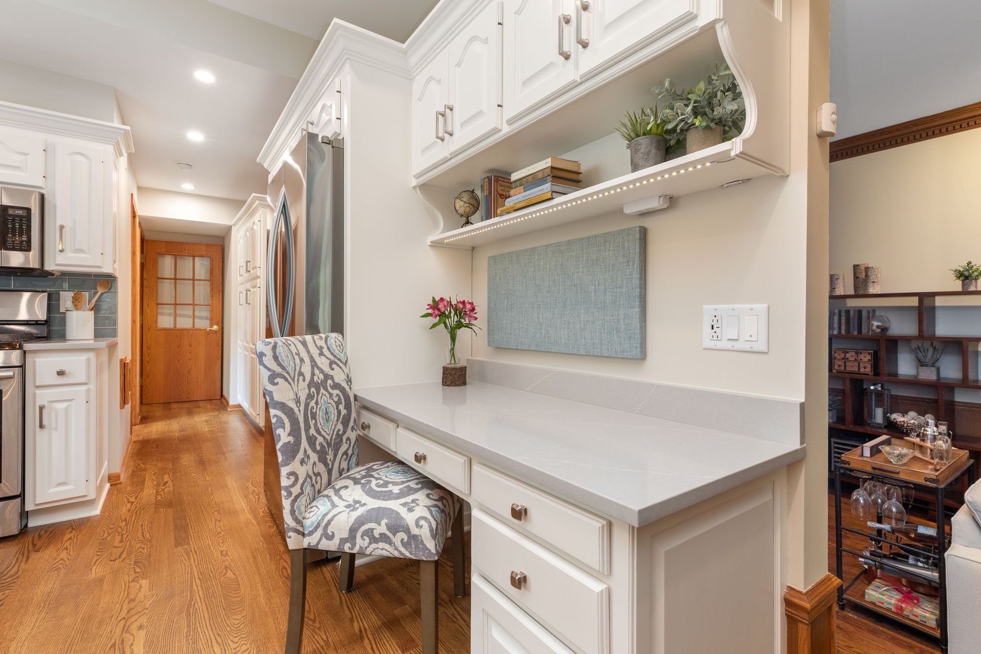 A kitchen with a desk and chair in it.