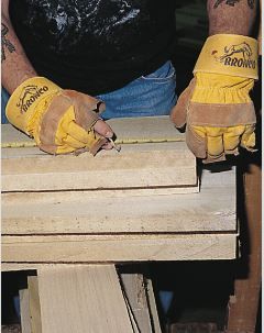 A person wearing yellow gloves that say bronco on them