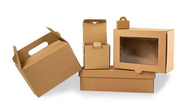 Cajas de cartón marrón y contenedores de embalaje dispuestos sobre un fondo blanco.