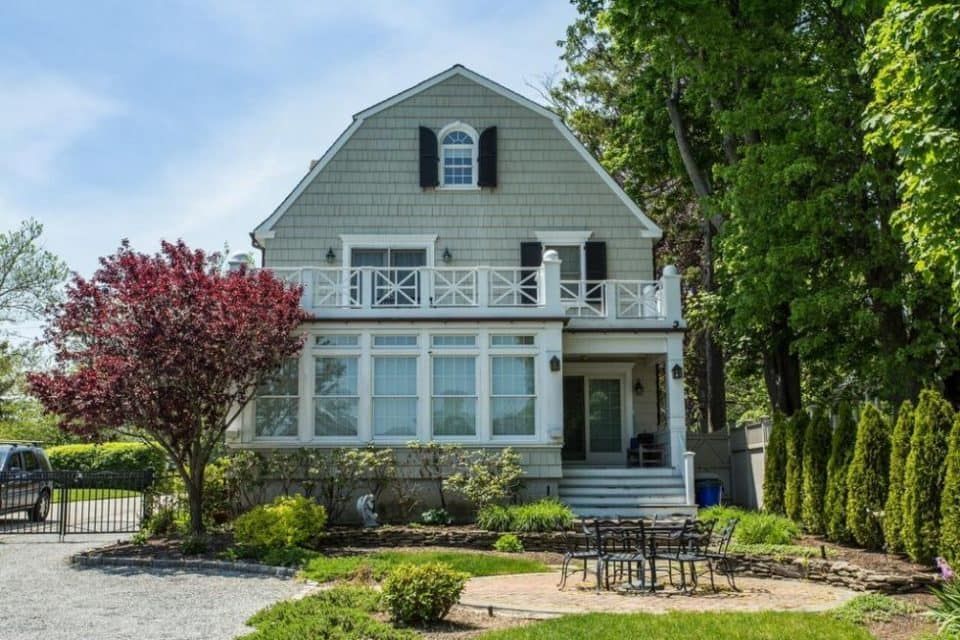 A large house with a lot of windows is surrounded by trees.