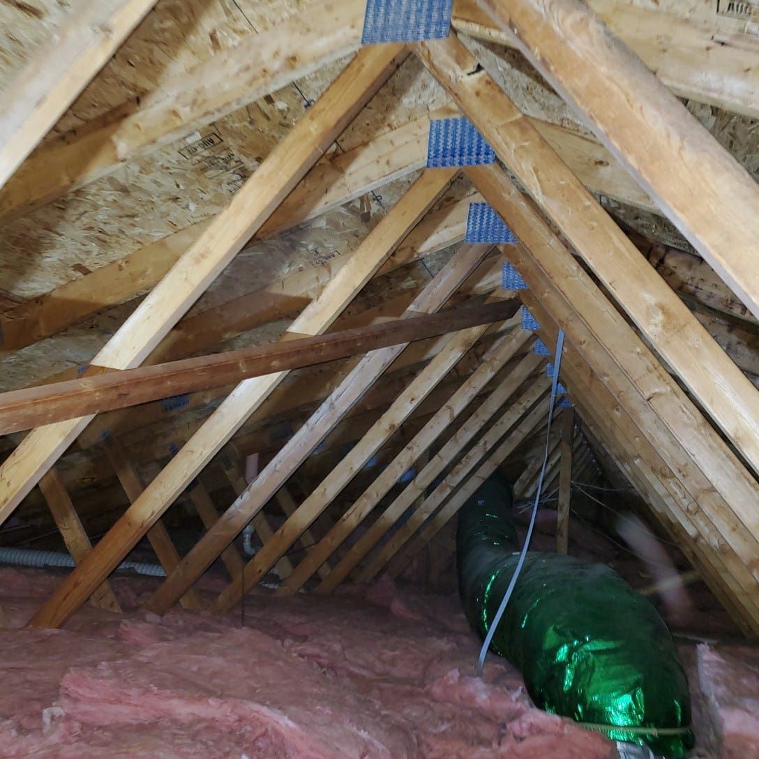 An attic with a green pipe going through it