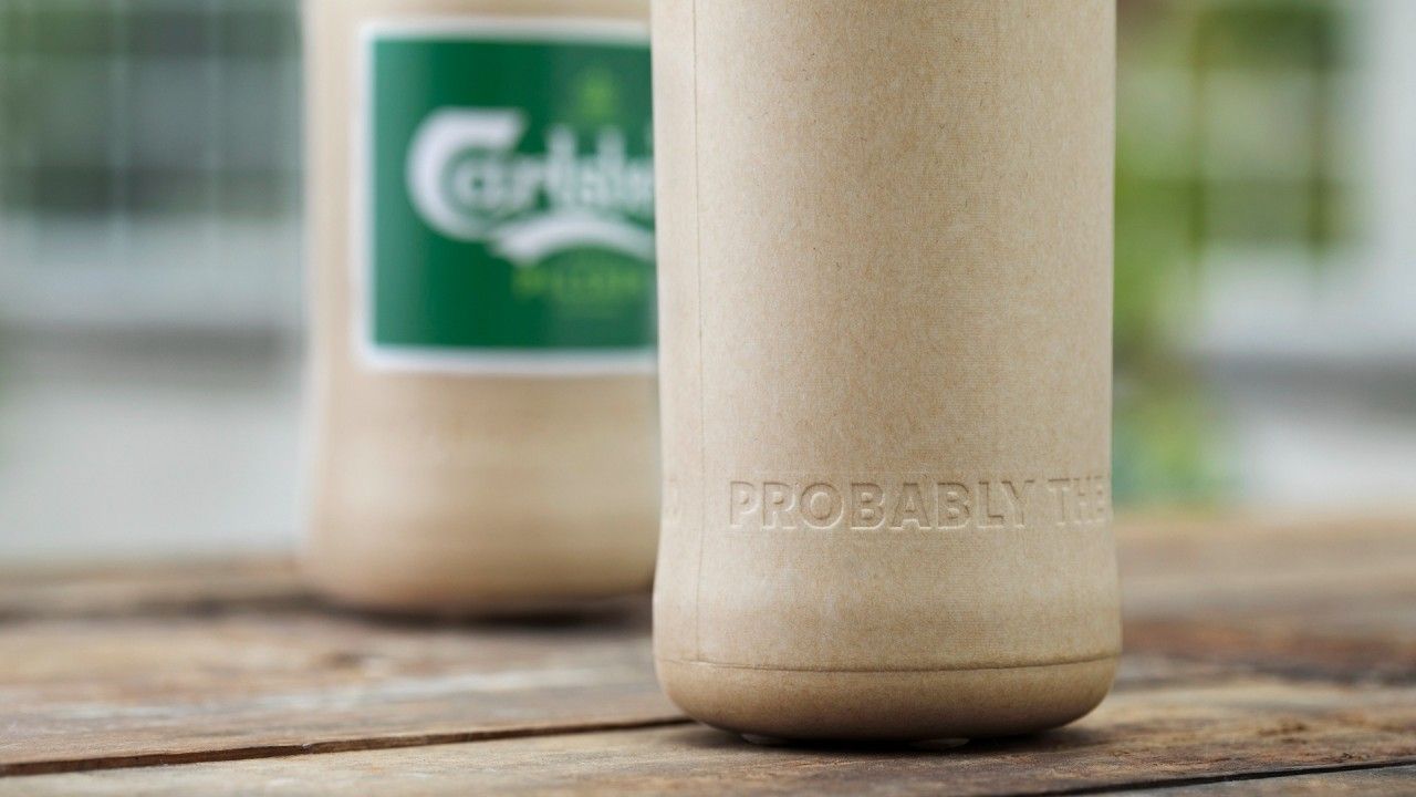 Two Carlsberg bottles, one in focus. Beige paper exterior with 