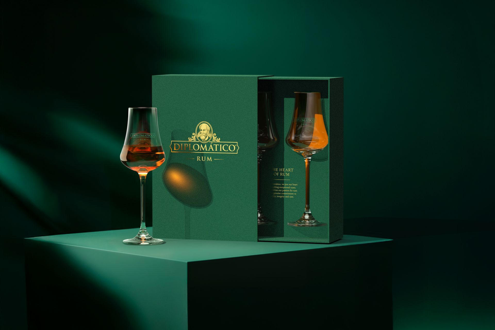 Green box set with two brandy glasses, one filled, on a green cube.