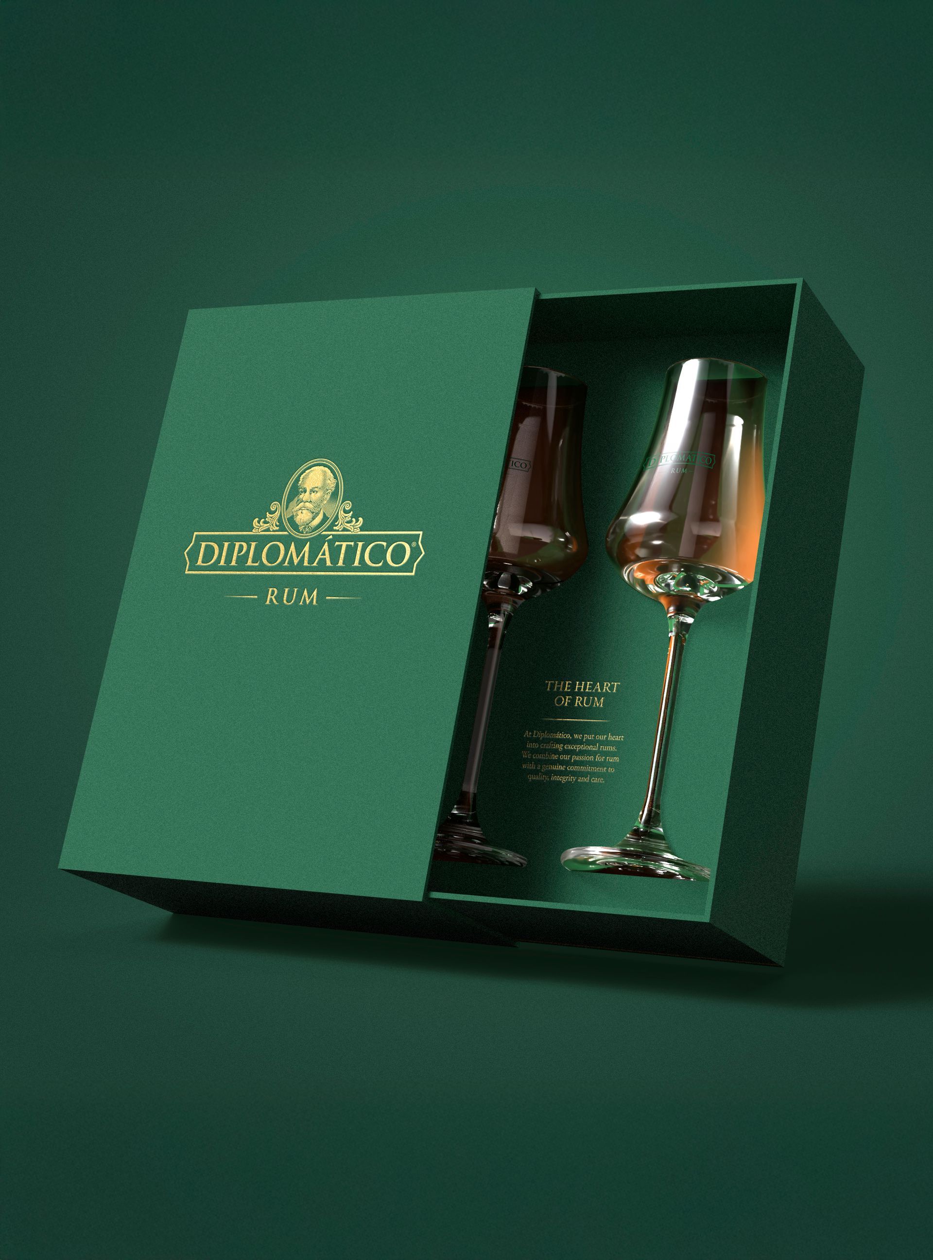 Green gift box with two stemmed glasses, likely for alcohol. Gold text on the box, green background.