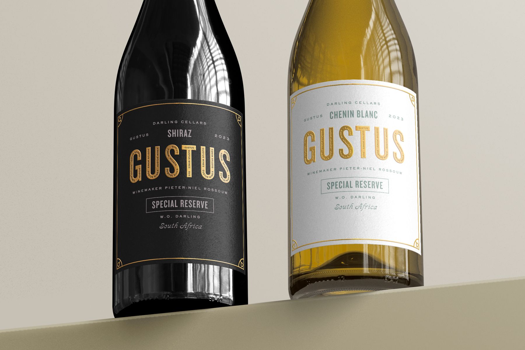 Two wine bottles, one black and one clear, with gold labels that say 