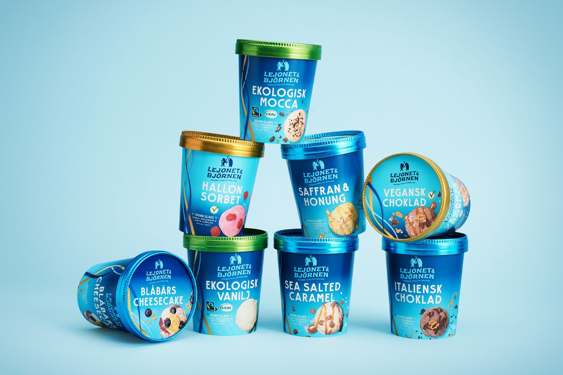 Ice cream pints stacked in a pyramid, various flavors, on blue background.