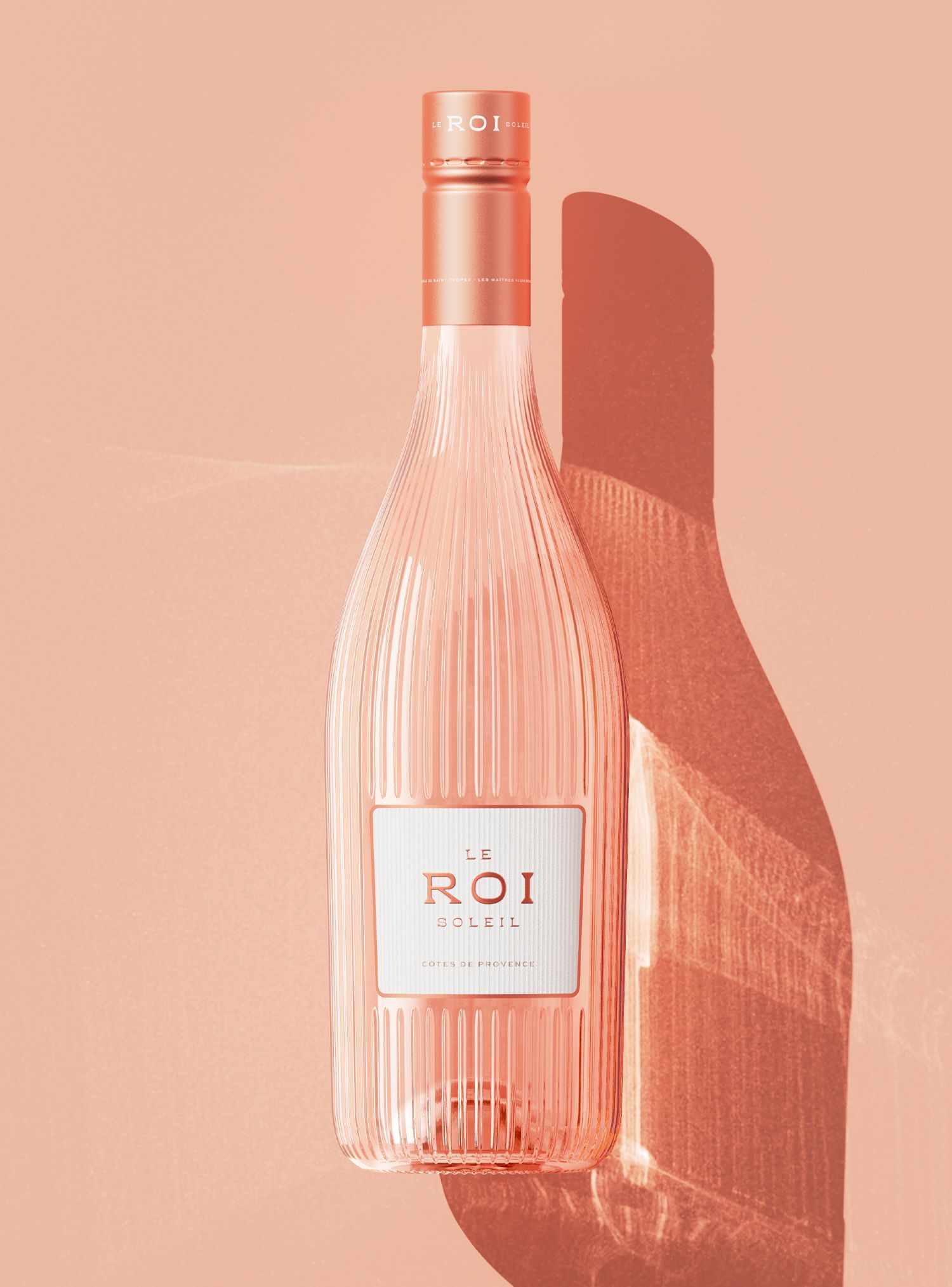 Rose wine bottle with textured glass and label, in front of a soft pink backdrop, casting a shadow.