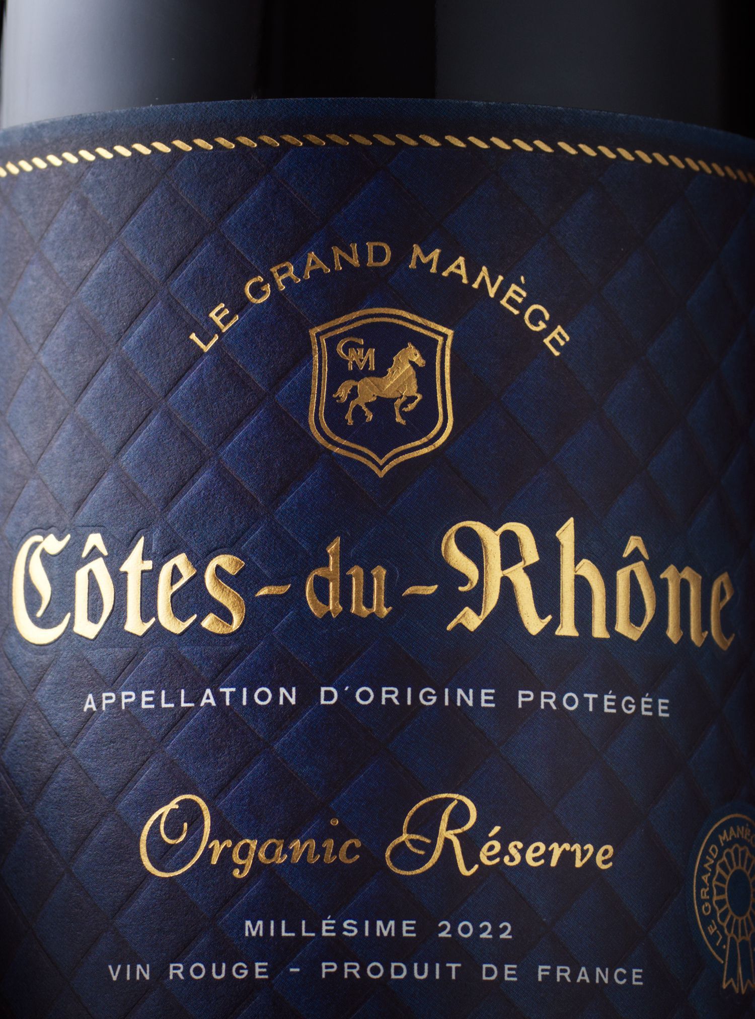 Dark blue wine bottle label with gold text: