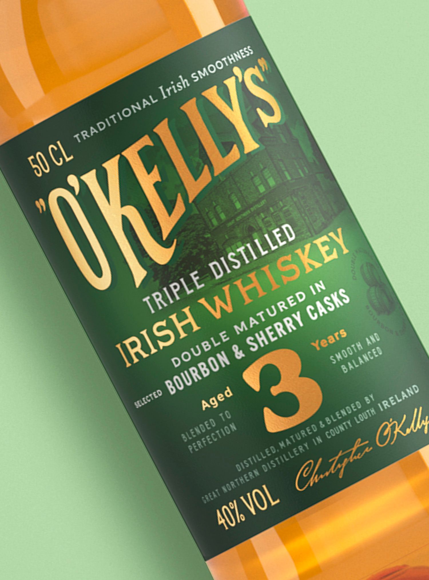 Bottle of O'Kelly's Irish whiskey, dark green label with gold lettering, aged 3 years, 40% ABV.