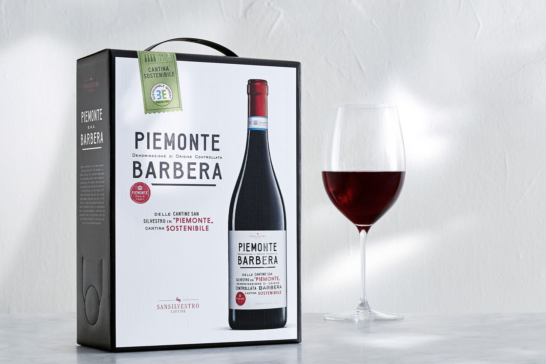 Boxed Piemont Barbera, San Silvestro, wine with a filled wine glass.