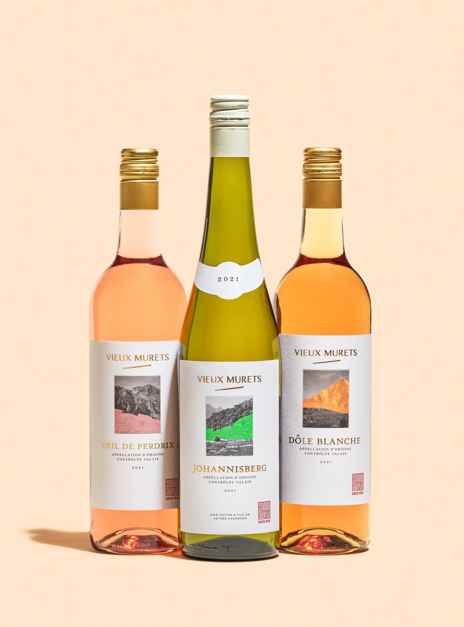 Three wine bottles: rose, white, and rose. Each has a label with a landscape scene.