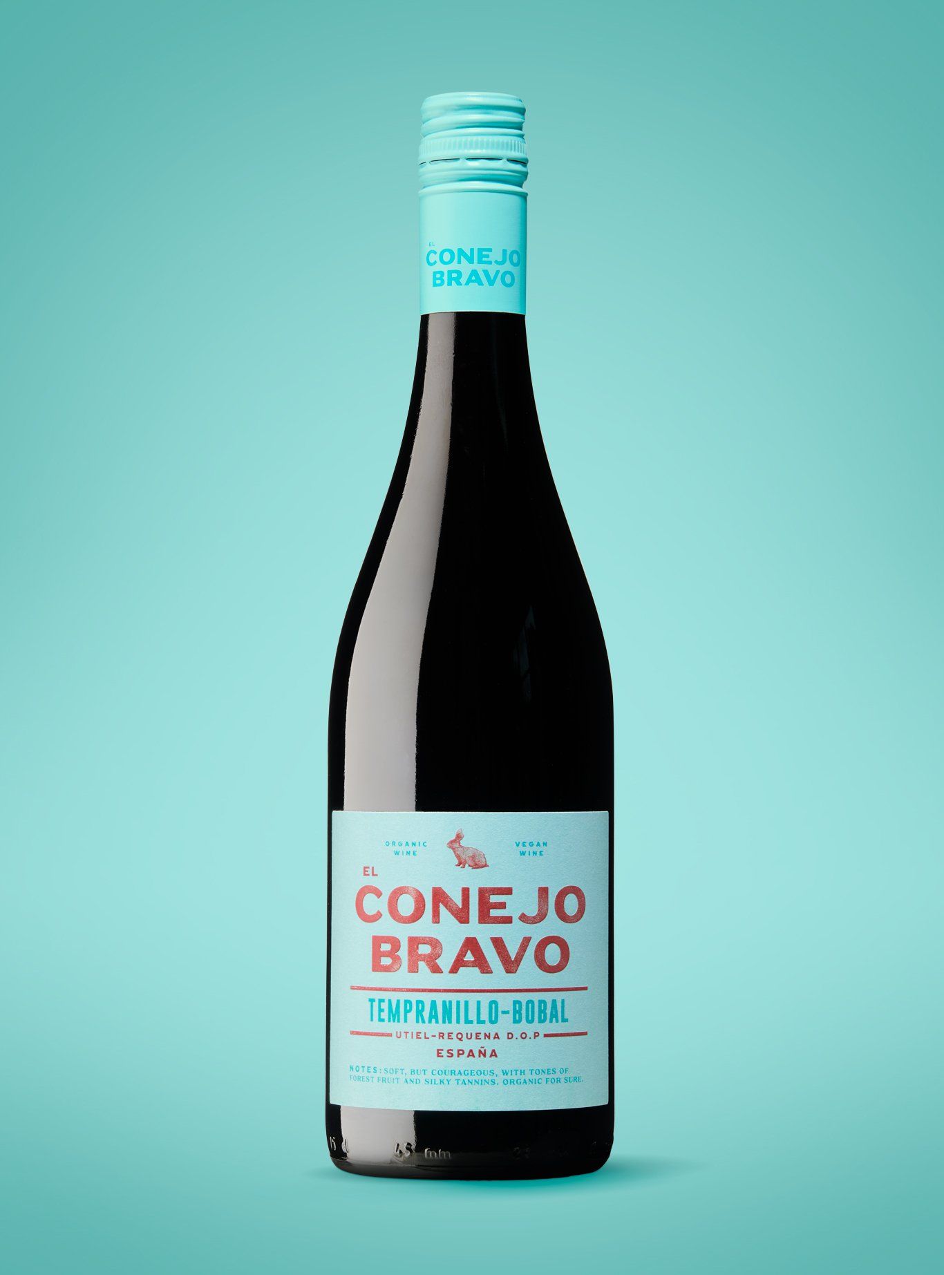 Bottle of Conejo Bravo wine with a turquoise label and cap, against a turquoise background.