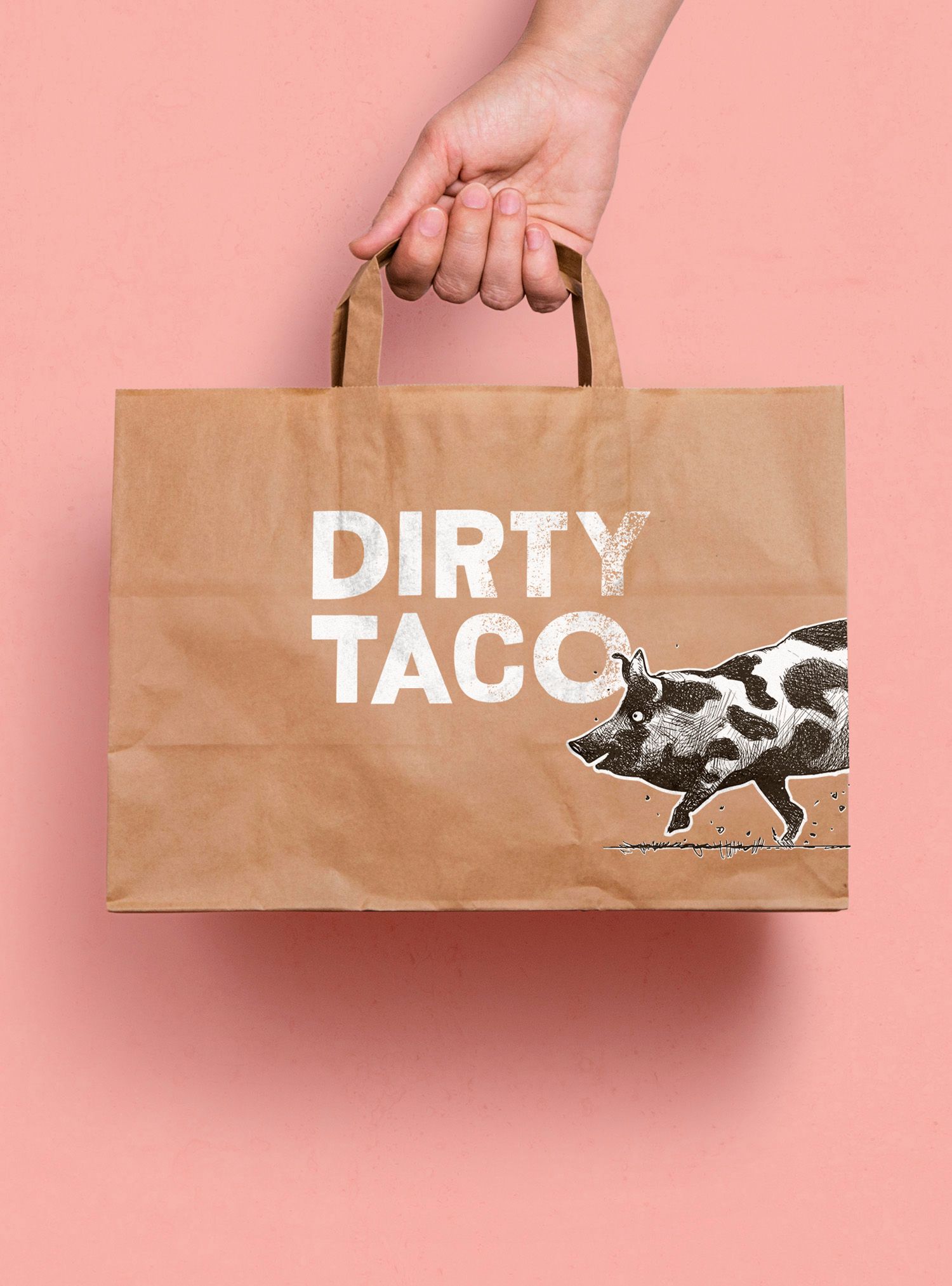 Hand holding a brown paper bag labeled 