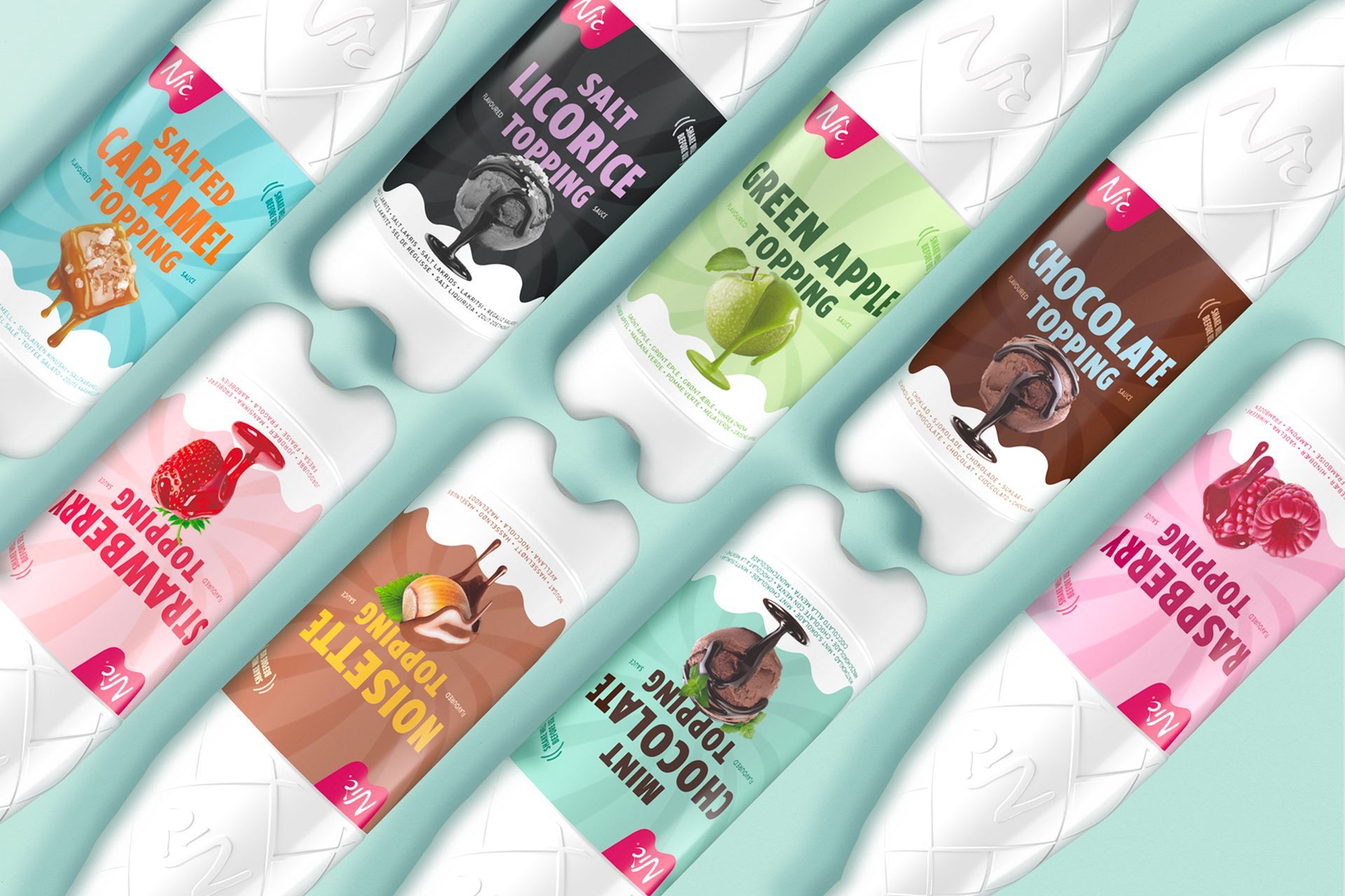 Tilted, angled display of ice cream topping bottles in assorted flavors: raspberry, caramel, chocolate, licorice, mint.