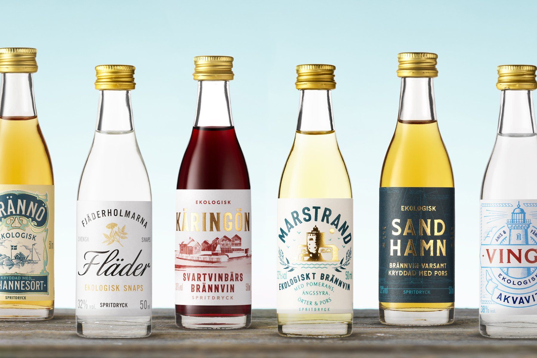 Six small bottles of liquor, snaps, with gold caps and colorful labels from Saturnus.