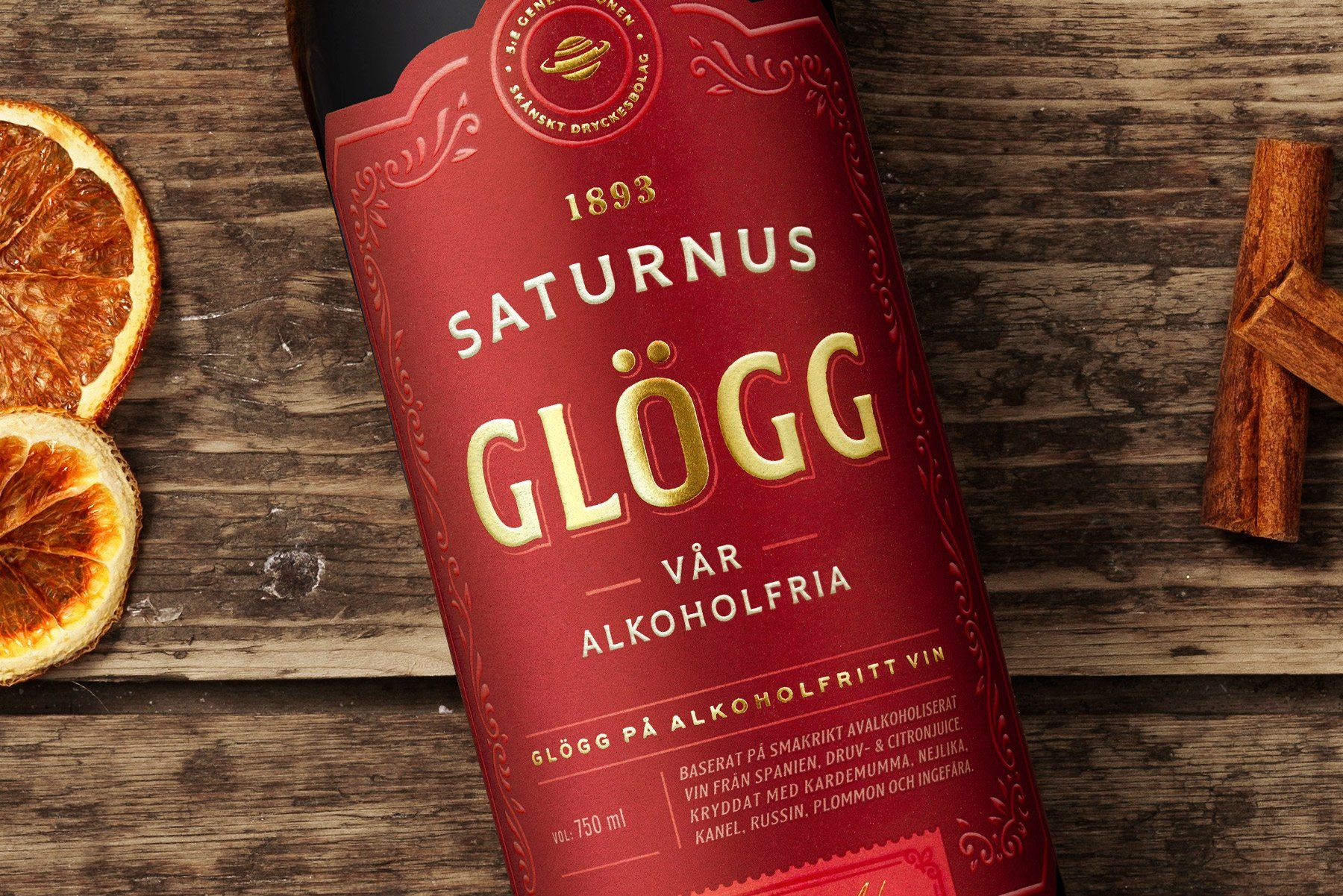 Bottle of Saturnus Glögg, a non-alcoholic beverage, with dried orange slice and cinnamon sticks.