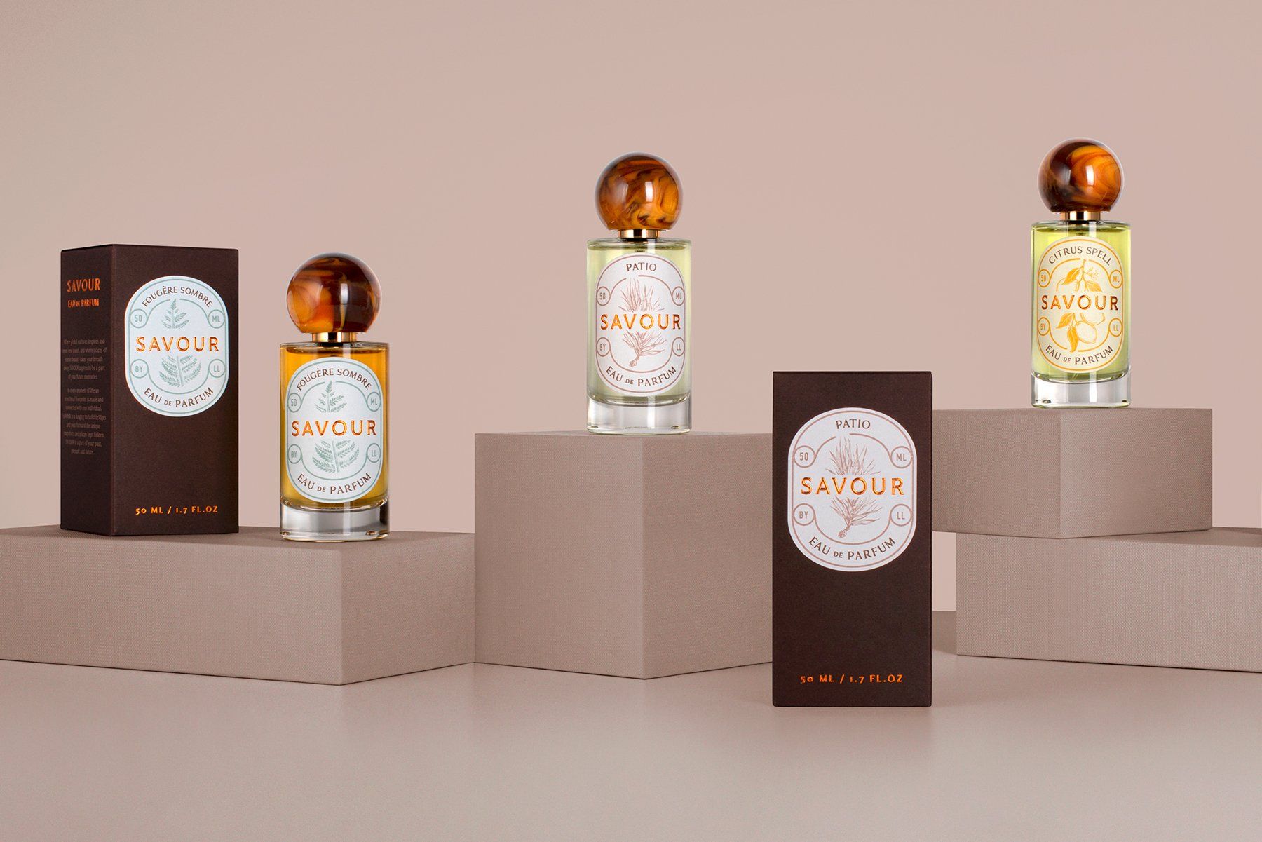 Perfume bottles and boxes displayed on geometric platforms against a light pink backdrop.