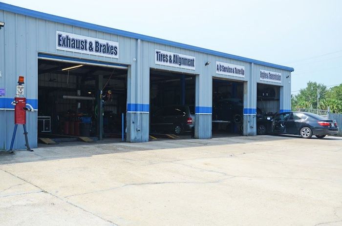 Auto repair shop bays with open garage doors and a car parked outside | Bayou Automotive