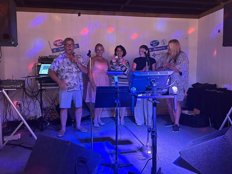 A group of people singing into microphones in a room