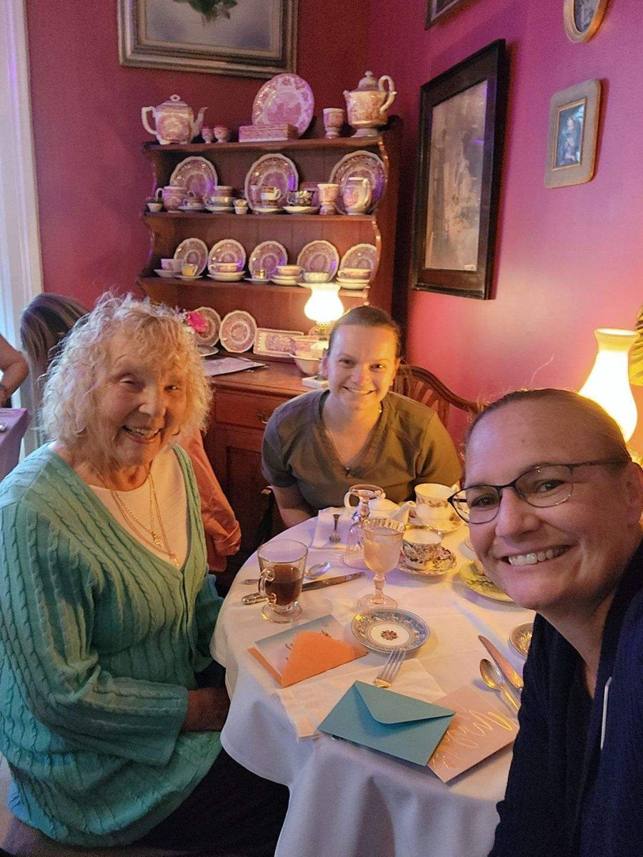 Three people are sitting at a table with plates on it