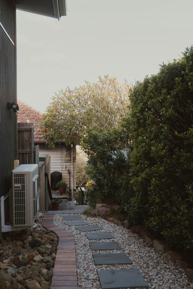 Side-yard path and rock treatment beside a home.