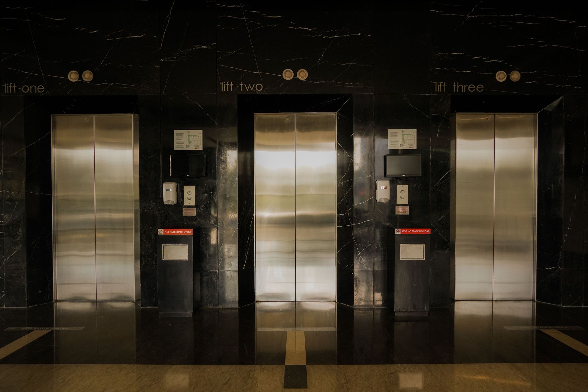 three elevator doors in a lobby