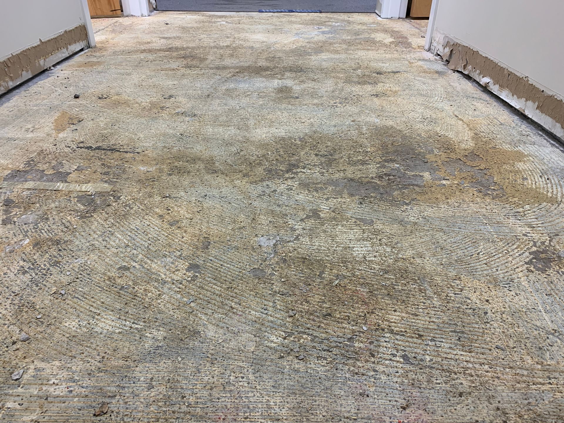Dirty, stained concrete floor in a hallway or garage area