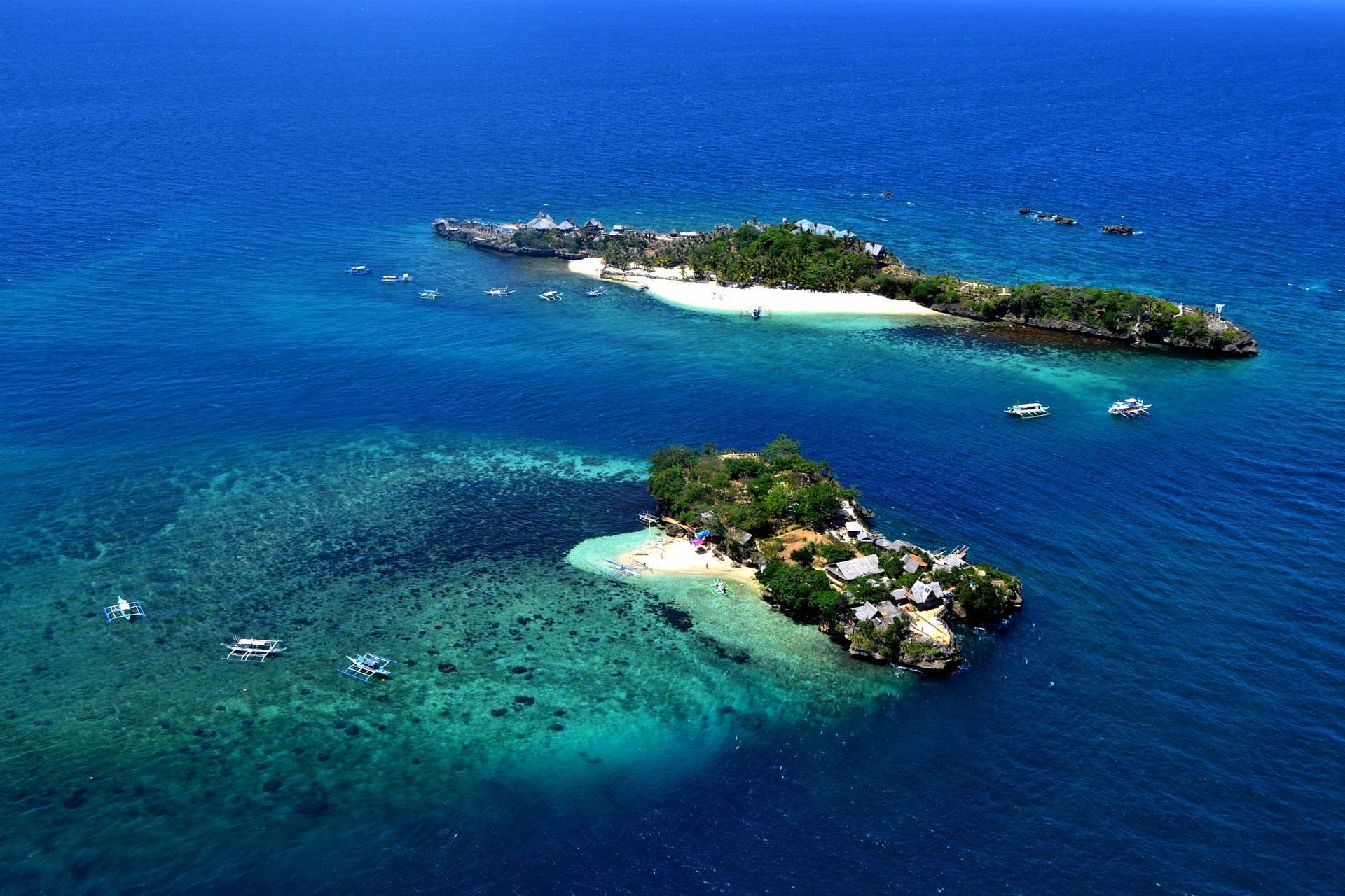 Two small tropical islands surrounded by turquoise water.