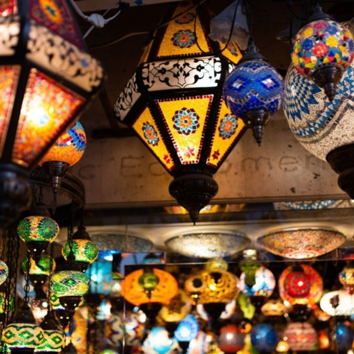 Colorful, ornate pendant lamps on display, each with unique mosaic and stained glass designs.