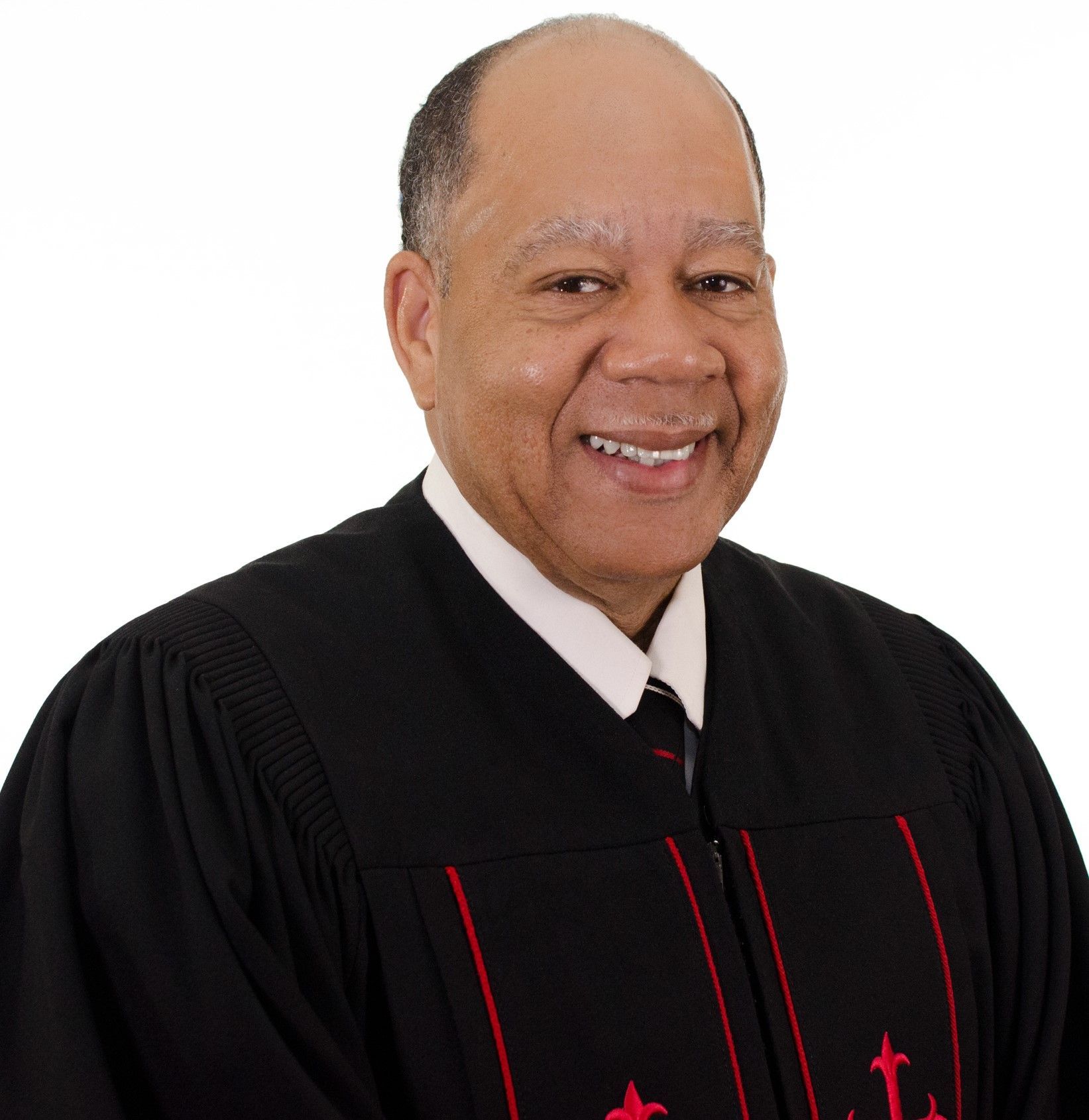 A man wearing a black robe with red arrows on it