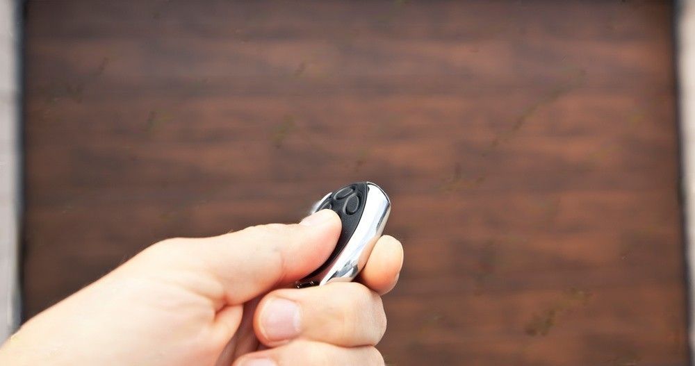 Man using a remote controller to open the garage door.