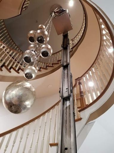A spiral staircase with a chandelier hanging from the ceiling