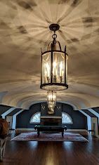 A living room with a chandelier hanging from the ceiling.