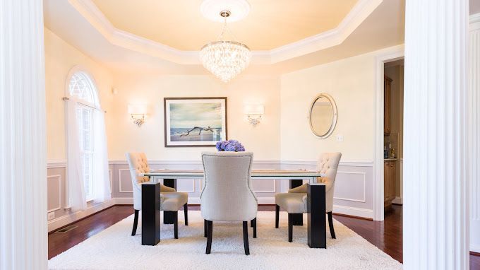 A dining room with a table and chairs and a chandelier.